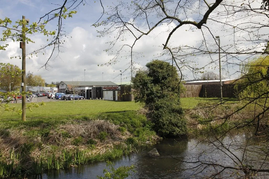 The Faraday Road football ground in Newbury, seen across the water that runs beside it