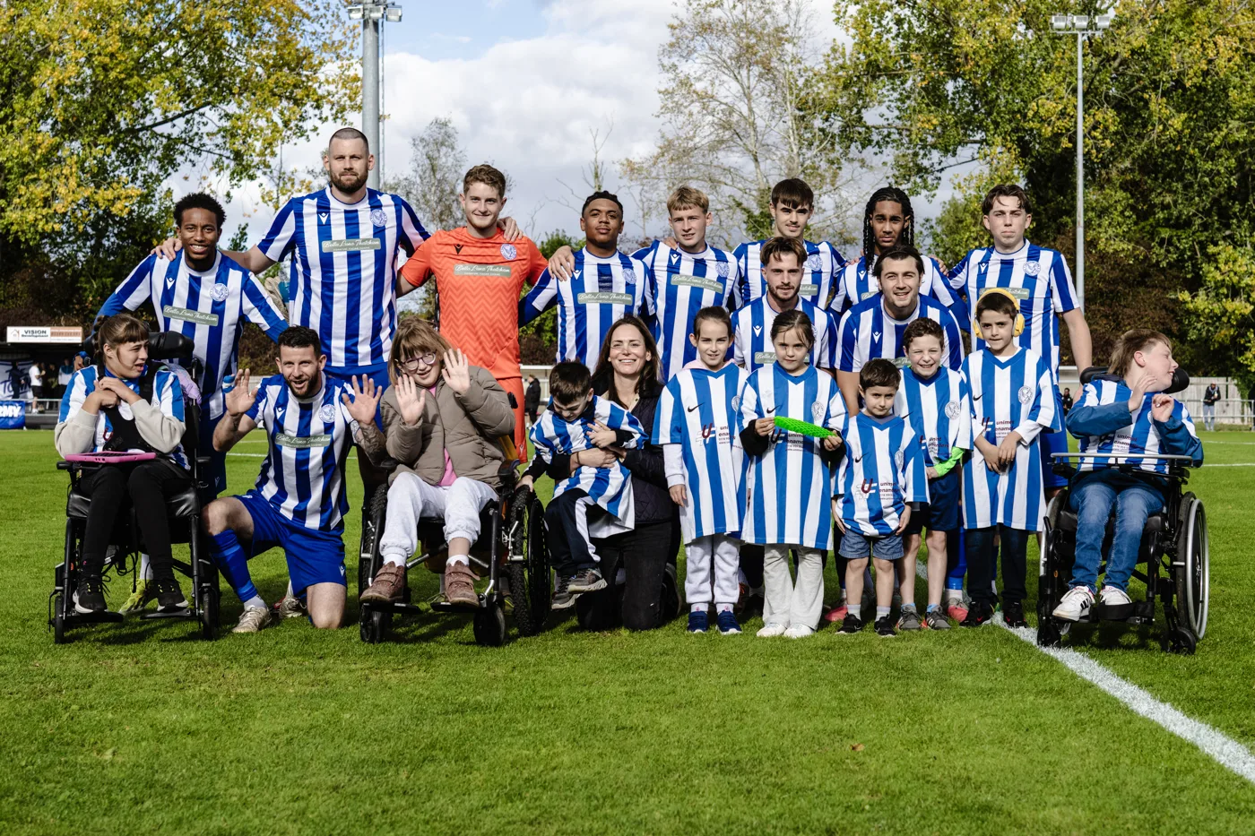 Swings & Smiles mascots in Thatcham Town shirts with the Kingfishers' first team on the pitch